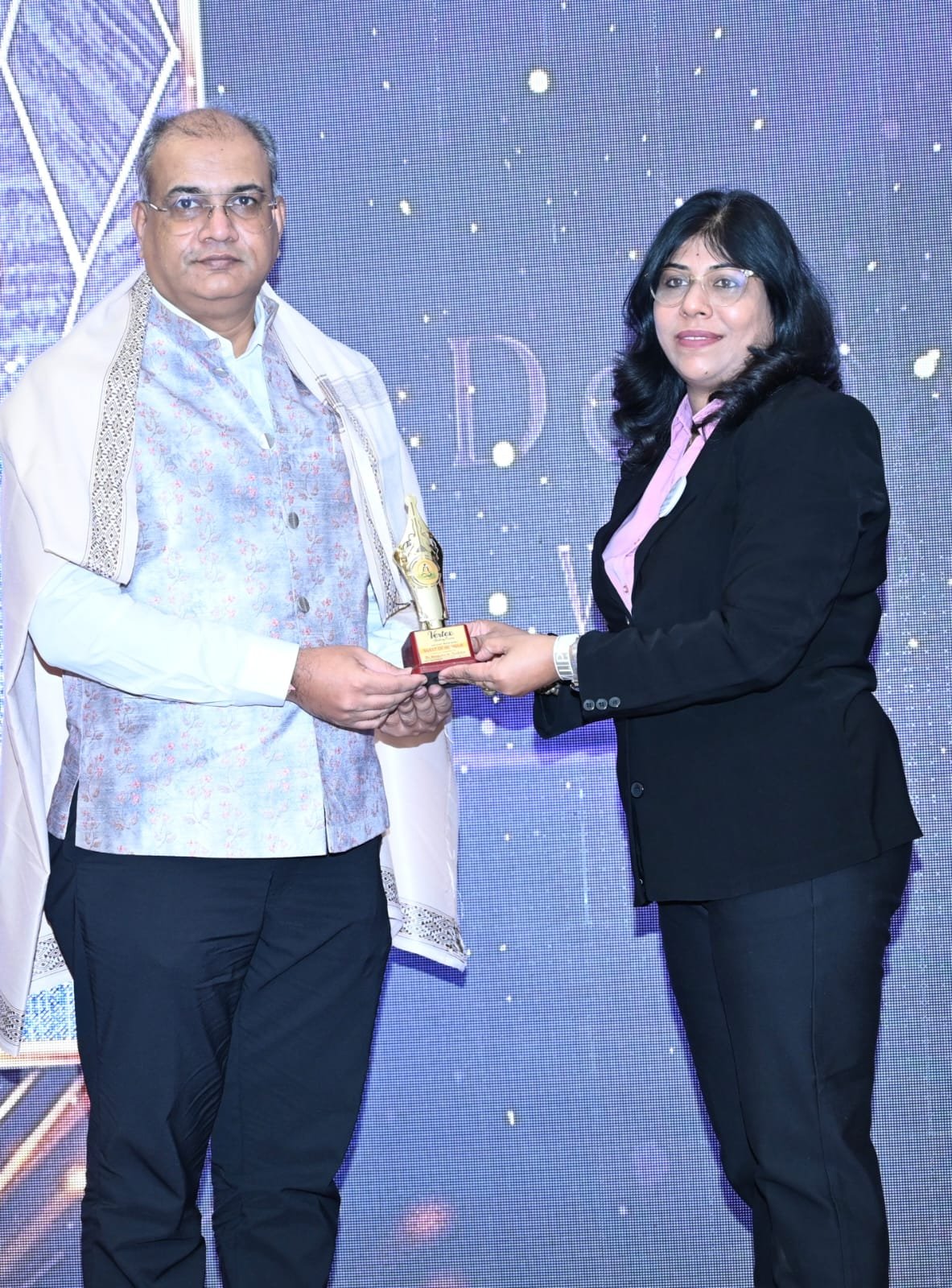 Kiran Pahade receiving a trophy at an awards ceremony